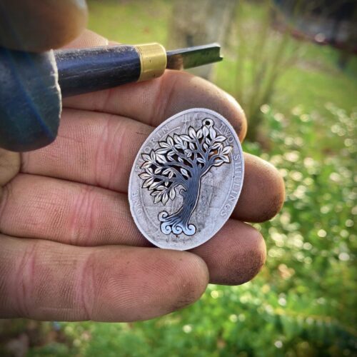 Handcrafted and recycled silver wind blown tree made from a silver coin in the workshop, Cambridge