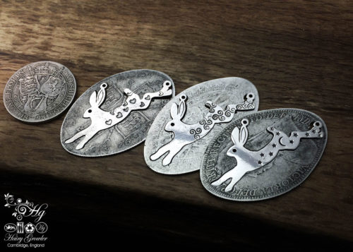 Handcrafted and recycled sterling silver magical leaping hare necklace being cut out of the silver coin