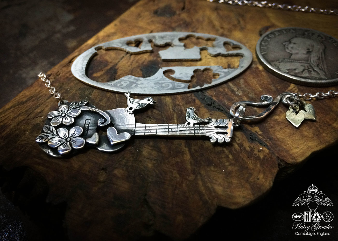 Handmade and upcycled sterling silver bird guitar necklace based on this silver Florin coin