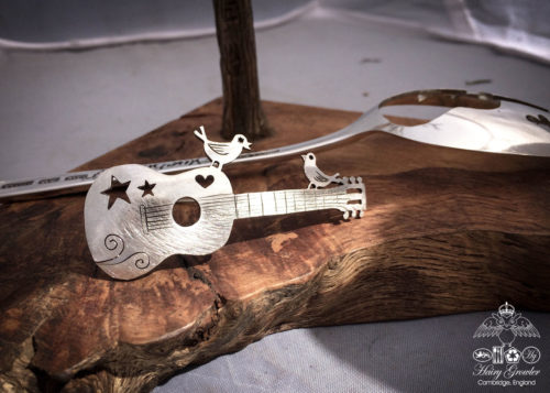 handcrafted and recycled spoon bird and guitar brooch
