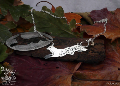 Handcrafted and recycled sterling silver leaping fox and dancing vixen necklace being cut out of the silver coin
