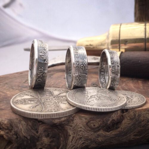 Handmade and recycled silver coin rings being sized in the workshop