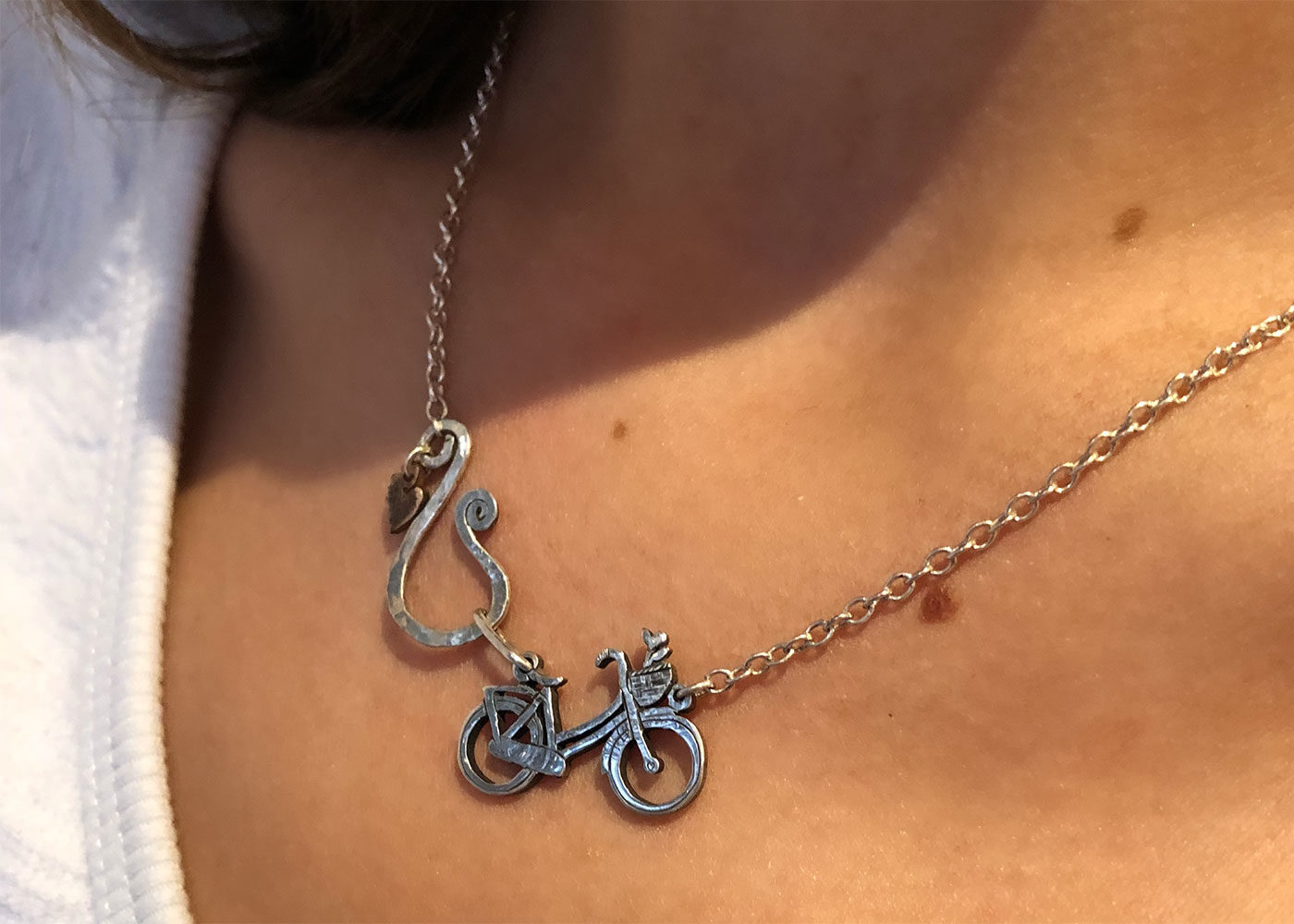 Bicycle necklace handcrafted and created with environmental awareness. Recycled silver coin jewellery made in Cambridge