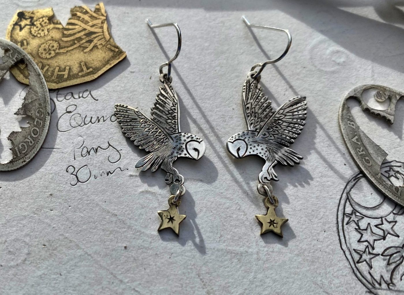 handcrafted and ethical silver flying barn owl earrings pouncing on a star recycled from silver coins