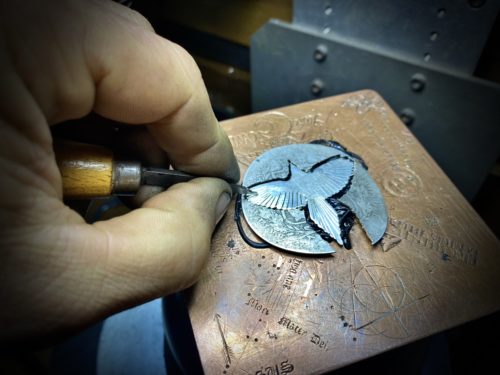 A handmade and and carved silver magpie in the making