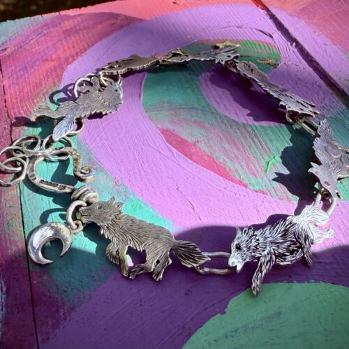 Wolf bracelet made from recycled silver shillings. A pack of wolves racing around your wrist.