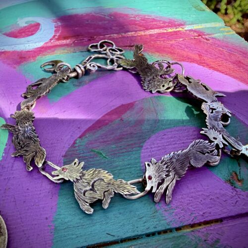 Wolf bracelet made from recycled silver shillings. A pack of wolves racing around your wrist.