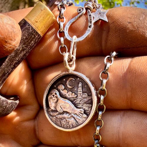 where the tide rests grey seal pendant with lighthouse made from silver shillings seahorses, northumberland
